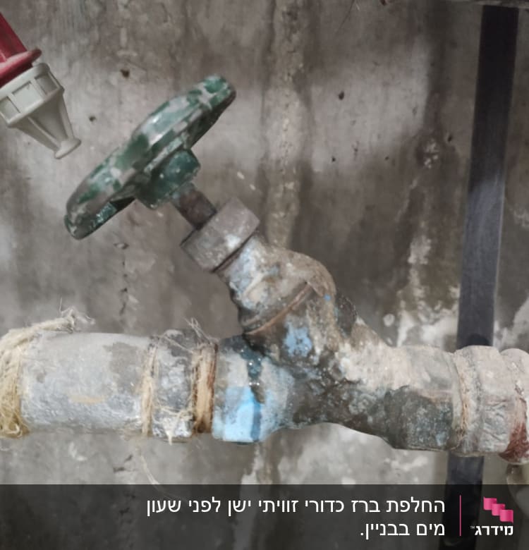 ברז מתכת ישן עם ידית ירוקה וחיבורים חלודים